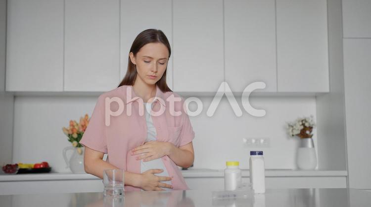 目を瞑っている妊婦 女性,人物,サプリメントの写真素材