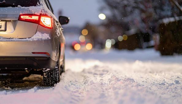 大雪が降った翌日の雪が積もった道を走る車 大雪が降った翌日の雪が積もった道を走る車の写真