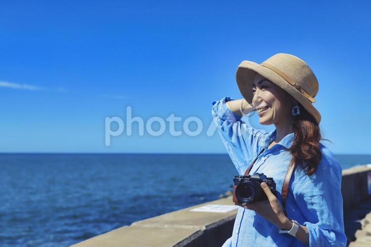 カメラを持って微笑む女性 カメラ,一眼レフ,旅の写真素材