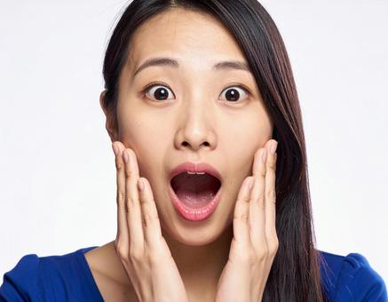 口を開けて驚く若い女性 口を開けて驚く若い女性の写真