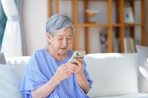 スマホを見つめるショートヘアの女性 女性,スマートフォン,持つの写真素材