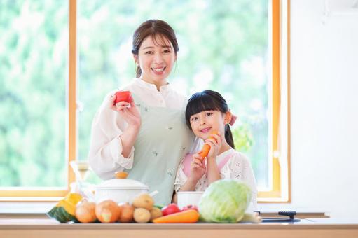 カメラ目線で野菜を持つ母子 カメラ目線で野菜を持つ母子 母,娘,トマトの写真素材