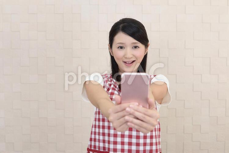 スマートフォンを持つ笑顔の女性 女性,主婦,女の写真素材