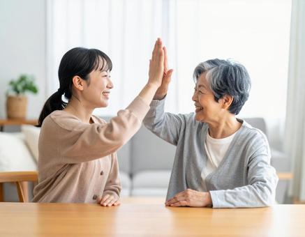 ハイタッチするおばあちゃんと孫 ハイタッチするおばあちゃんと孫の写真