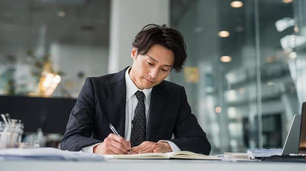 デスクワークをする日本人男性 デスクワークをする日本人男性の写真