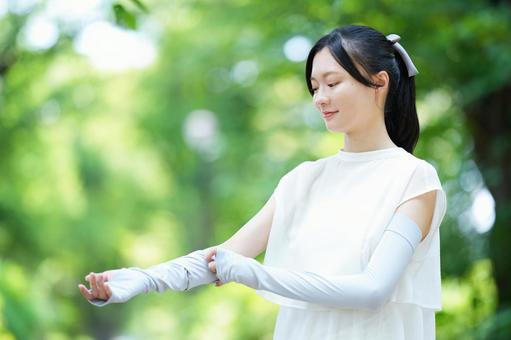 女性が片手を前に伸ばす 女性,微笑む,アームカバーの写真素材