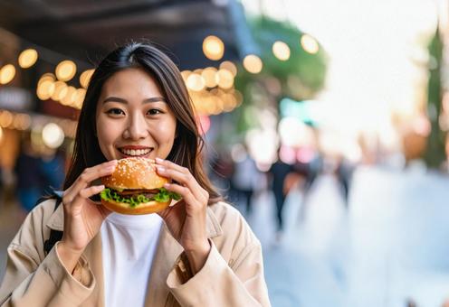 気になる 店のハンバーガーを食べる若い女 気になる 店のハンバーガーを食べる若い女の写真