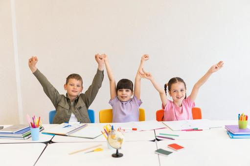 カメラ目線で万歳する生徒たち 男の子,女の子,子どもの写真素材