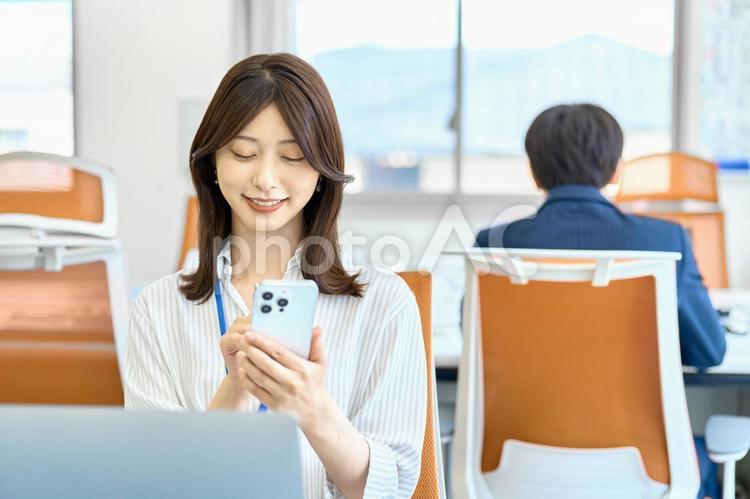 スマホを使う女性　ビジネス　デスクワーク ビジネスウーマン,スマホ,デスクワークの写真素材