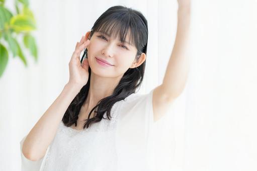 リビングでスキンケアをするミドルの女性 ビューティー,スキンケア,女性の写真素材