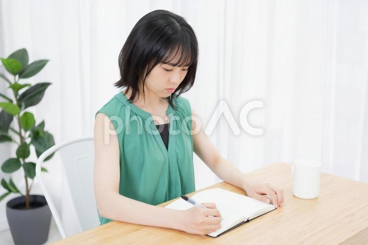 ノートに文字を書いている若い女性 ノート,女性,若いの写真素材
