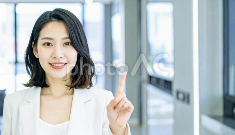 自信のある表情で指さすビジネス女性 指さす,指差し,ビジネスの写真素材