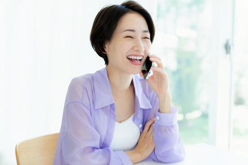 スマホで電話するミドル女性 スマホ,笑顔,女性の写真素材