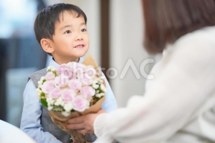 おばあちゃんに花束を渡す孫 家族,三世代家族,おばあちゃんの写真素材