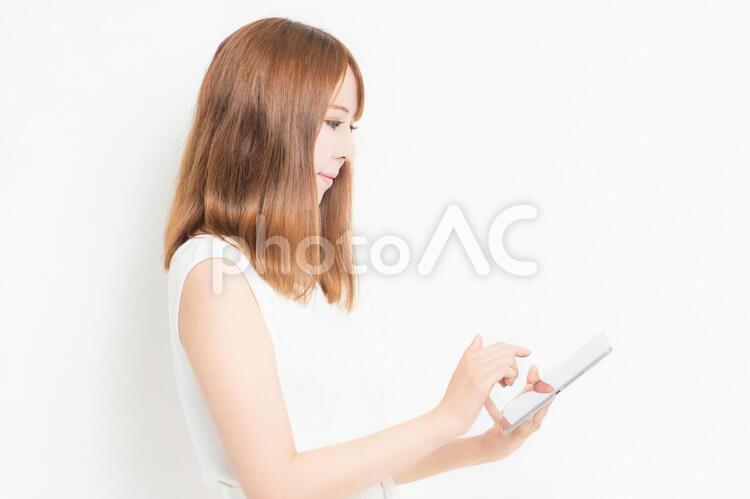 タブレット端末を使うワンピースを着た女性 女性,タブレット,snsの写真素材