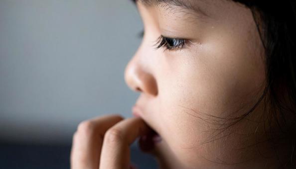 指しゃぶりをする子供の横顔 指しゃぶりをする子供の横顔の写真