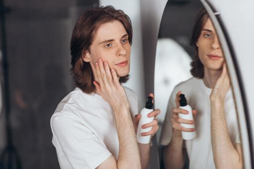 楕円形の鏡の前でスキンケアしている男性 男性,外国人,欧米人の写真素材