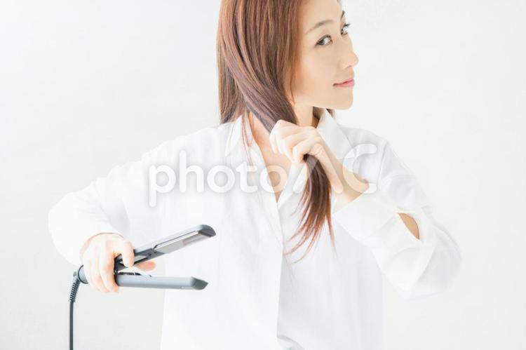 ヘアアイロン（コテ）を使う女性 髪,ヘアアイロン,ヘアセットの写真素材
