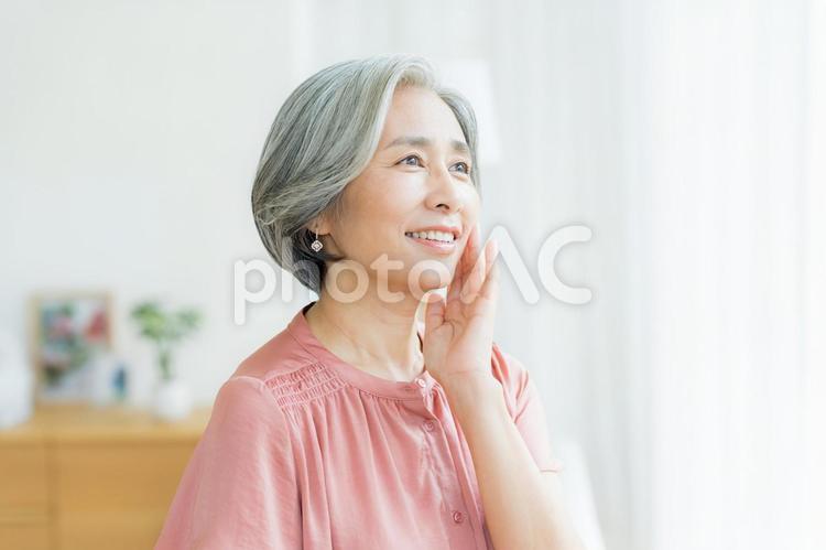スキンケアをするシニア女性 美容,シニア,笑顔の写真素材