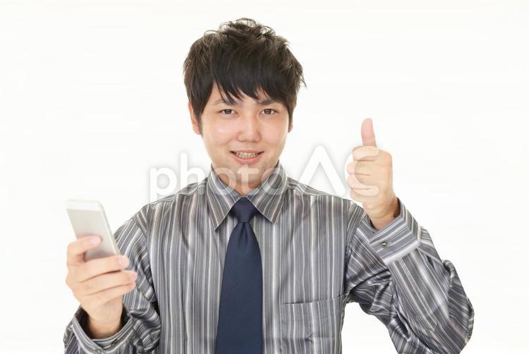 スマホを持っていいねのポーズをとる男性 男性,スマホ,ビジネスの写真素材