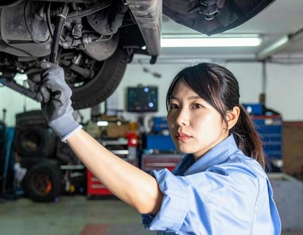 自動車工場でエンジン整備する女性スタッフ 自動車工場でエンジン整備する女性スタッフの写真