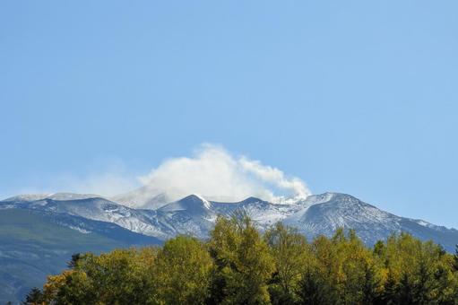 山頂に雪と煙でかすんだ青空の十勝岳連峰 山頂に雪と煙でかすんだ青空の十勝岳連峰 美瑛,白ひげの滝,十勝岳連峰の写真素材