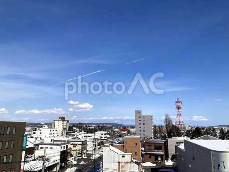 雪解けの街並みと飛行機雲 街並み,市街地,ビルの写真素材