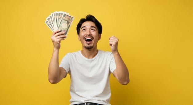 大金を手にして喜ぶ男性 大金を手にして喜ぶ男性の写真