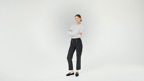 腕組みをして立ち微笑む女性 腕組みをして立ち微笑む女性の写真