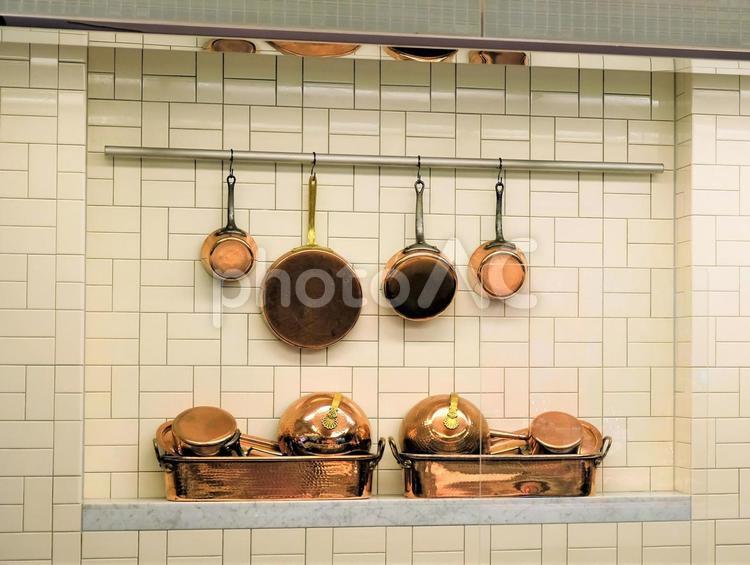 タイルの壁にかけられた銅製フライパンと綺麗な銅製調理器具 銅製,調理器具,調理用具の写真素材