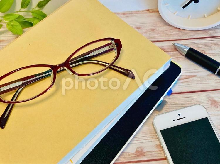 木目調の上の本と眼鏡とスマホ ノート,本,読書の写真素材