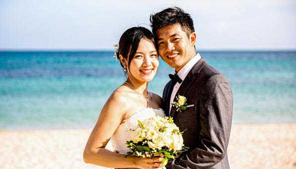 ブーケを持ち顔を見合わせる新郎新婦 ブーケを持ち顔を見合わせる新郎新婦の写真