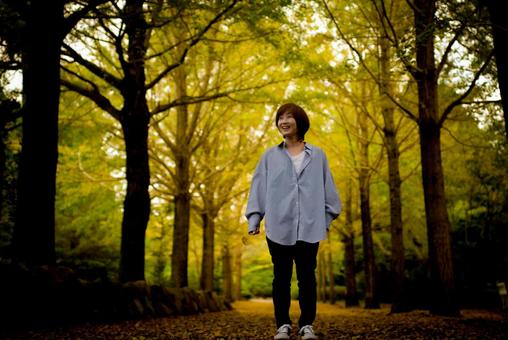 <素材>紅葉のイチョウ並木を観光する女性 <素材>紅葉のイチョウ並木を観光する女性 女性,笑顔,紅葉の写真素材