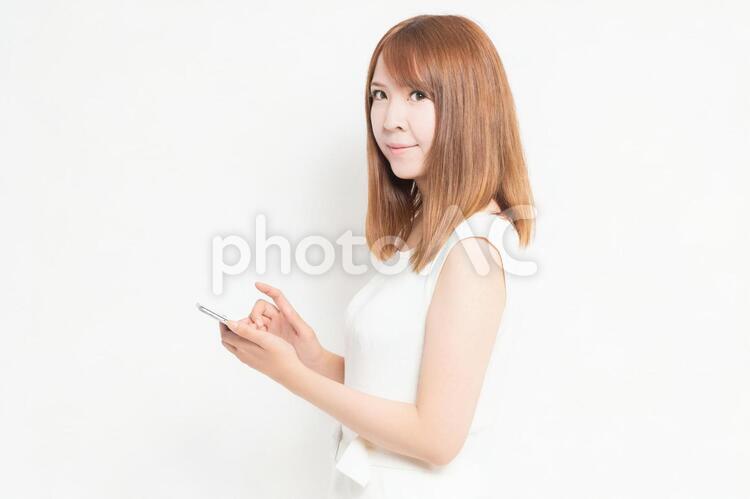 スマホを操作するワンピースを着た女性 女性,スマホ,snsの写真素材