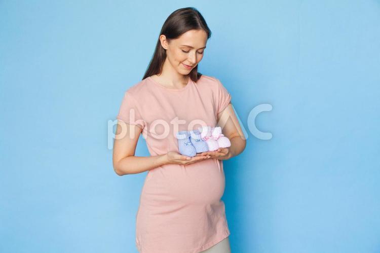 ベビーシューズを持って見ている女性 女性,人物,ピンクの写真素材