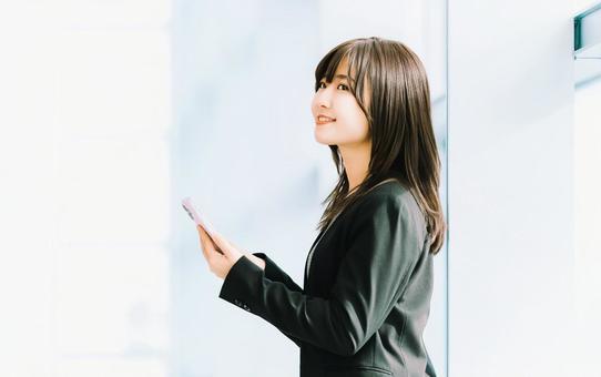 スマホを使う笑顔の女性・ビジネスウーマン スマホを使う笑顔の女性・ビジネスウーマン 女性,スマホ,スマートフォンの写真素材