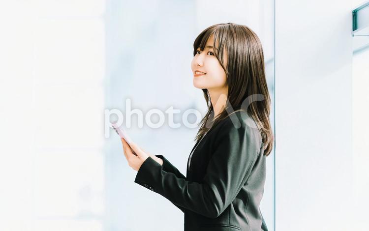スマホを使う笑顔の女性・ビジネスウーマン 女性,スマホ,スマートフォンの写真素材