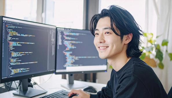 プログラミングをする男性エンジニア プログラミングをする男性エンジニアの写真