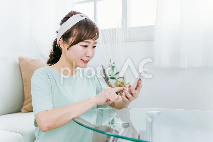 スマホを使う笑顔の日本人女性（アプリ） スマホ,女性,スマートフォンの写真素材