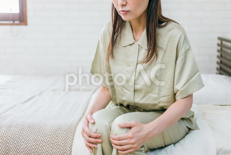 ベッドルームにいるミドル世代の女性（膝） 膝,ひざ,膝痛の写真素材