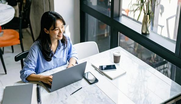カフェで仕事をするフリーランス女性 カフェで仕事をするフリーランス女性の写真