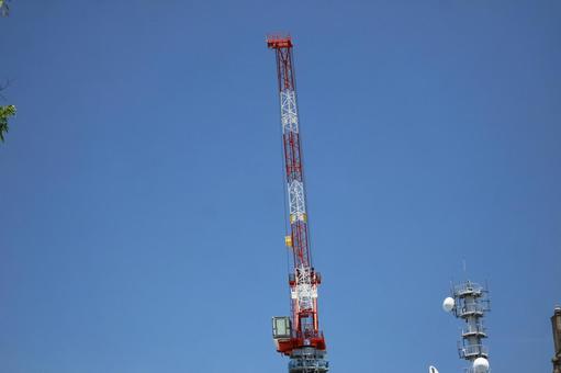 青空とクレーンと電波塔のある風景の写真