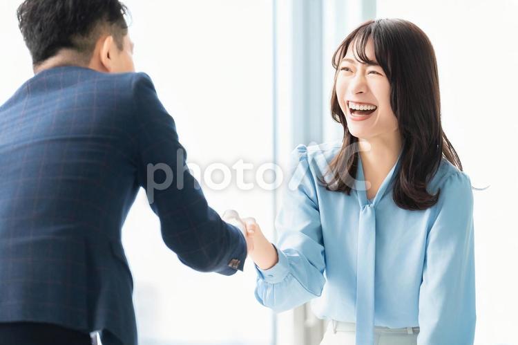 笑顔で握手をする男女2人のビジネスマン 男性,女性,ビジネスの写真素材