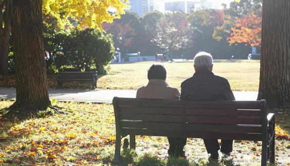 ベンチでくつろぐ熟年夫婦 ベンチでくつろぐ熟年夫婦の写真