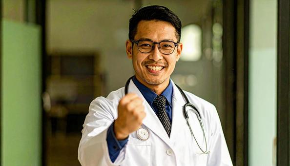ガッツポーズをする日本人の男性医師の写真