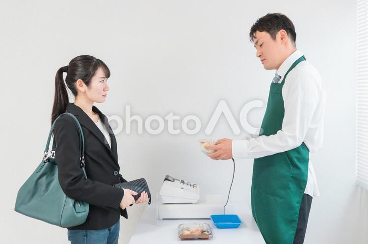 お弁当を買う女性と態度が悪いコンビニ店員 レジ,トラブル,クレームの写真素材