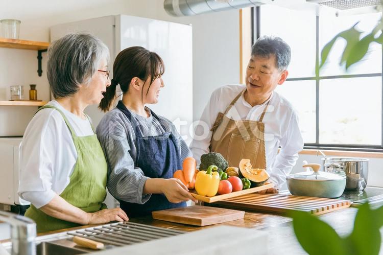 野菜を持つ高齢者夫婦と若い日本人（介護） 栄養士,家族,野菜の写真素材