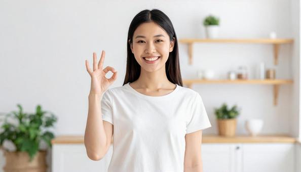 笑顔でOKサインをする白Tシャツ姿の女性 笑顔でOKサインをする白Tシャツ姿の女性の写真