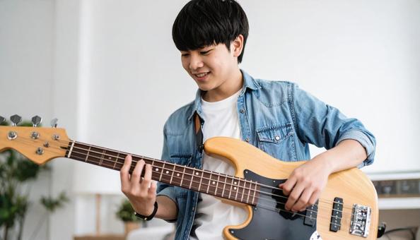 ベースを演奏する若い日本人の男の子 ベースを演奏する若い日本人の男の子の写真
