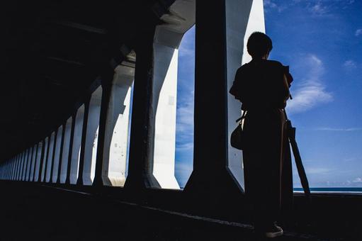 <素材>窓あきトンネルから空を眺める女性 <素材>窓あきトンネルから空を眺める女性の写真